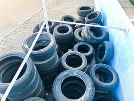 Warehouse of used black spoiled rubber, tires, wheels for cars photo