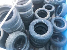 Warehouse of used black spoiled rubber, tires, wheels for cars photo