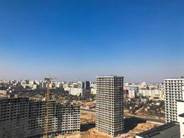 Building with the help of construction cranes of high reinforced concrete, panel, cast-frame, frame-block houses, buildings, skyscrapers, new buildings on the background of sandy land photo