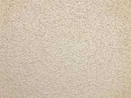 The texture of the rough wall of beige decorative plaster used for wall decoration of entrances. The background photo