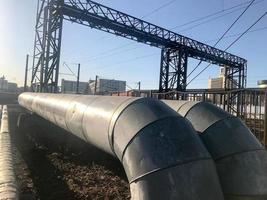 grandes tubos de metal grueso para bombear líquidos, agua, vapor, aceite, gas licuado en aislamiento térmico de fibra de vidrio, lana mineral, estaño, galvanizado en una refinería, petroquímica, planta química foto