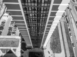 la vista desde la altura del techo de un edificio alto y grande de una casa de rascacielos en el patio con camiones frente al otro edificio de bloques de marco azul del nuevo edificio foto