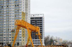 A large modern construction site in the construction of buildings and houses with appliances and many large high tower and stationary industrial powerful cranes and building materials photo