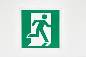 The sign of the direction to the evacuation exit on the wall in the shopping center photo