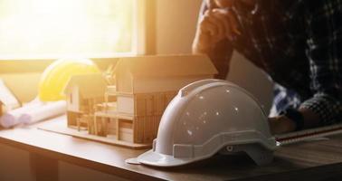 Construction engineer working at blueprint to build large commercial buildings in office. Engineering tools and construction concept. photo