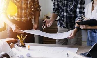 Construction engineer working at blueprint to build large commercial buildings in office. Engineering tools and construction concept. photo