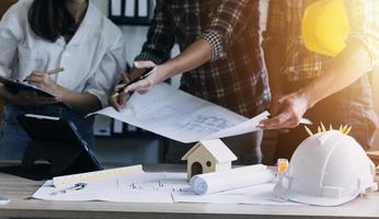 Construction engineer working at blueprint to build large commercial buildings in office. Engineering tools and construction concept. photo