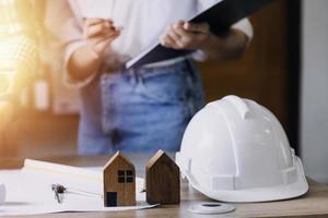 Construction engineer working at blueprint to build large commercial buildings in office. Engineering tools and construction concept. photo