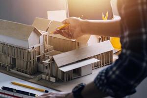 Construction engineer working at blueprint to build large commercial buildings in office. Engineering tools and construction concept. photo
