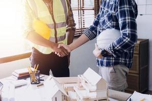 Construction engineer working at blueprint to build large commercial buildings in office. Engineering tools and construction concept. photo