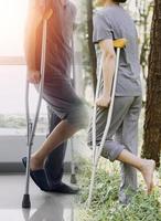 joven fisioterapeuta asiática que trabaja con una anciana caminando con un andador