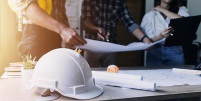 Construction engineer working at blueprint to build large commercial buildings in office. Engineering tools and construction concept. photo