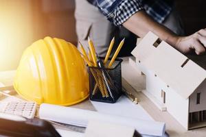Construction engineer working at blueprint to build large commercial buildings in office. Engineering tools and construction concept. photo