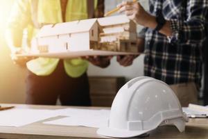 Construction engineer working at blueprint to build large commercial buildings in office. Engineering tools and construction concept. photo