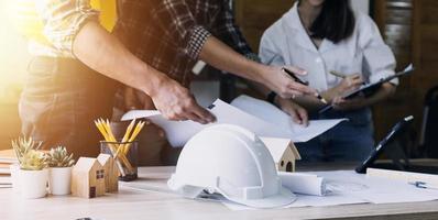 Construction engineer working at blueprint to build large commercial buildings in office. Engineering tools and construction concept. photo