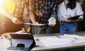 Construction engineer working at blueprint to build large commercial buildings in office. Engineering tools and construction concept. photo