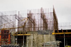 The process of construction and repair of a new modern cement concrete stone pannel monolithic frame-block building of a house with iron reinforcement at an industrial construction site photo