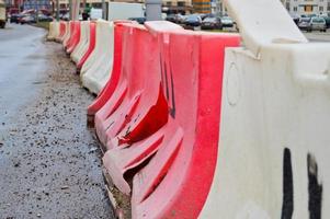 grandes bloques de plástico rojo y blanco llenos de agua para la seguridad vial durante la reparación de carreteras foto
