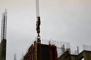 The process of construction and repair of a new modern cement concrete stone pannel monolithic frame-block building of a house with iron reinforcement at an industrial construction site photo