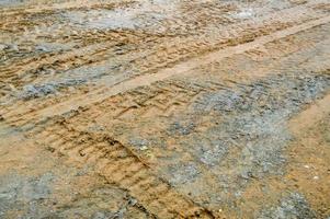 textura de un camino de tierra sucio y sucio camino de tierra con charcos y barro secado de arcilla con grietas y surcos. fuera del camino. el fondo foto