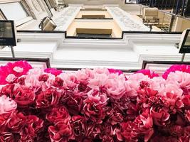 The decoration of the house, the facade of the building with red pink roses and peony flowers. The background photo