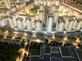 Top view on the toy layout of the city with residential neighborhoods, lanterns, roads, highways, houses, buildings and parking lots, skyscrapers at night. Panorama of the city photo