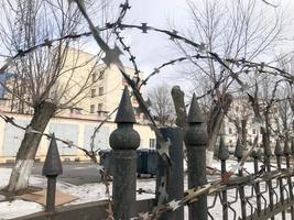 Iron metal sharp dangerous protective barbed wire on the fence with spikes and stakes against the sky photo