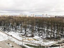 la vista desde la ventana del antiguo cementerio de la ciudad en el parque desde una altura con árboles y casas en invierno. panorama de la ciudad foto