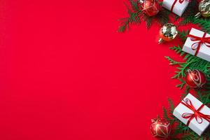 cajas de regalo y decoración festiva. composición navideña sobre fondo rojo. foto