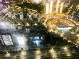 Top view on the toy layout of the city with residential neighborhoods, lanterns, roads, highways, houses, buildings and parking lots, skyscrapers at night. Panorama of the city photo