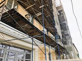Repair work on the facade of the building with the help of wooden scaffolding, structures, restoration of the old house photo