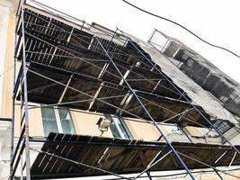 Repair work on the facade of the building with the help of wooden scaffolding, structures, restoration of the old house photo