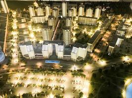 Top view on the toy layout of the city with residential neighborhoods, lanterns, roads, highways, houses, buildings and parking lots, skyscrapers at night. Panorama of the city photo