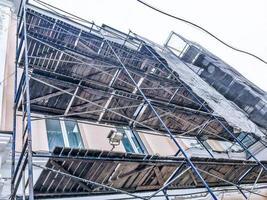 Repair work on the facade of the building with the help of wooden scaffolding, structures, restoration of the old house photo