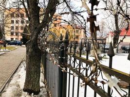 Iron metal sharp dangerous protective barbed wire on the fence with spikes and stakes against the sky photo