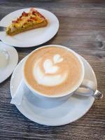 Delicious fragrant cappuccino with a pattern on the surface of the foam in a white porcelain cup photo