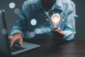 woman Hand holding Light bulb Global Internet connection. Business global internet connection application technology and digital marketing, Financial and banking, Digital link tech, big data. photo