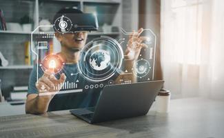 Asian man wearing VR glasses virtual global Internet connection metaverse, point finger use finger touch digital unlock, Metaverse technology management, online access to database, future technology. photo
