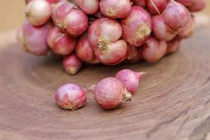 Shallots still on wood background photo