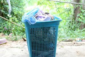 Pile of clothes overflow plastic laundry basket for washing photo