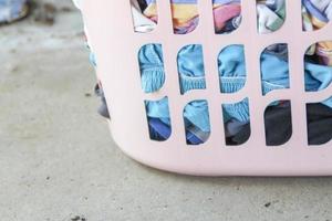 Pink Basket with dirty laundry on floor. photo