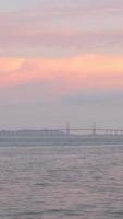 timelapse vertical nuageux coucher de soleil rayon sur le pont de penang au-dessus de l'océan reliant l'île de penang au coucher du soleil vanille sky time, célèbre point de repère en malaisie