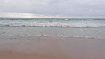 slowmotion de l'eau naturelle des vagues de la mer avec de la mousse sur la plage blanche de beauté sablonneuse video