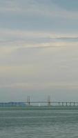 verticale lasso di tempo nuvoloso tramonto raggio al di sopra di Penang ponte al di sopra di oceano collegamento Penang isola con tramonto vaniglia cielo tempo, famoso punto di riferimento nel Malaysia video