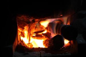 quema de leña en la estufa para cocinar, brasas, carbones encendidos foto
