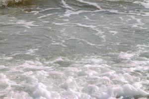 white soft wave rolling splash on empty tropical sandy beach in sunny day photo