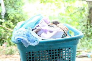 Pile of clothes overflow plastic laundry basket for washing photo