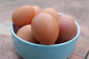 Close-up view of raw chicken eggs in blue bowl photo