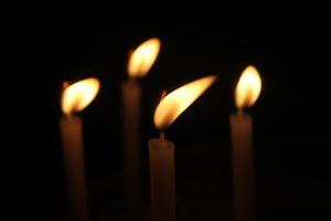 candles burning brightly on black background photo