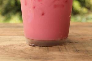 Closeup top view ice of strawberry sweet milk pink in takeaway cup. photo